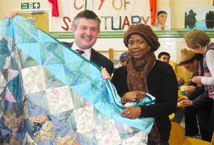 Jon with Stella Ngorima showing the quilt she and other asylum seekers made at the Drop In